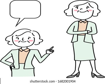 Senior businesswoman with blank text bubble. Mature woman in suit pointing and making a gesture to blank speech balloon. Portrait of confident female presenter in suit standing with folded arms.