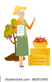 Senior caucasian farmer holding clipboard with papers and giving thumb up on the background of tree, crates and basket of apples. Vector flat design illustration isolated on white background.