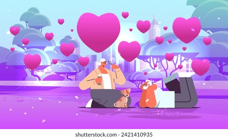 senior couple in love blowing bubbles and spending time with little dog in urban park valentines day celebration concept horizontal