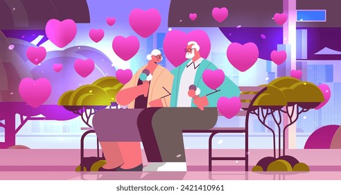 senior couple in love eating ice cream grandparents with pink hearts spending time together in park valentines day celebration
