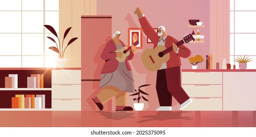 senior couple playing guitar grandparents having fun active old age concept home kitchen interior horizontal