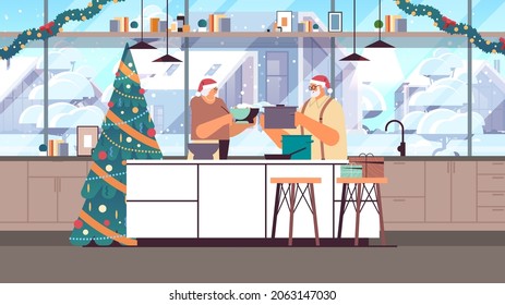 Senior Couple In Santa Hats Cooking Together In Kitchen Christmas Dinner Preparation New Year Holidays Celebration Concept