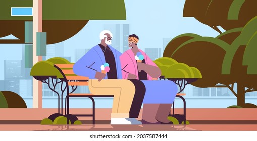 senior couple sitting on bench and eating ice cream happy african american grandparents spending time together in park