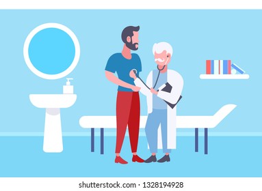 senior doctor examining male patient by stethoscope checking heart beat or breath medicine healthcare concept modern hospital room interior full length horizontal