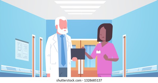 senior doctor and nurse medical team discussing in hospital corridor healthcare concept modern clinic interior portrait horizontal flat