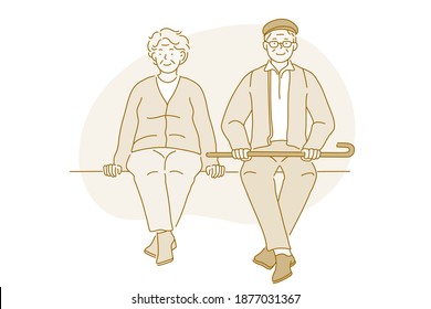 Senior elderly couple living happy active lifestyle concept. Happy mature aged couple pensioners woman and man sitting together on bench during walk looking at camera. Retiree, pensioner happiness