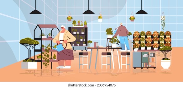 senior gardeners couple taking care of potted plants and flowers at greenhouse home garden interior