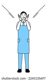 A senior man in an apron calling out and his hand over his mouth 