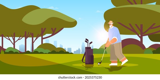 senior man playing golf on green golf course aged player taking a shot active old age concept landscape background