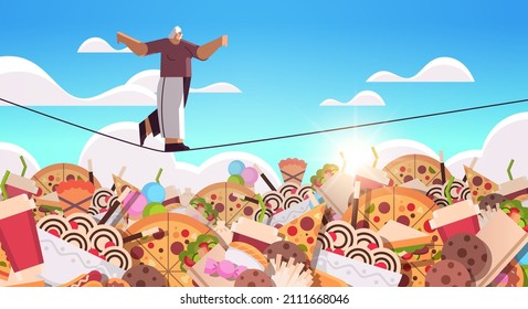 senior woman balancing on rope above junk food assortment of fast food unhealthy nutrition junkfood addiction