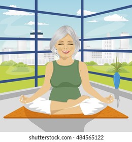 senior woman doing yoga exercises in lotus position sitting on mat