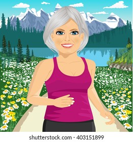 Senior woman jogging among beautiful mountains and field of daisy flowers