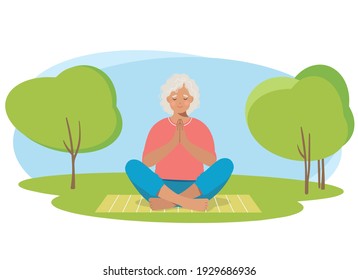 Senior woman meditating and exercising yoga lotus position in nature.