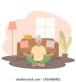 Senior woman meditating.  Woman in a yoga pose, in a lotus position in the living room. 