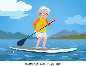 Mujer mayor en una tabla de remo. La abuelita se viste con la guardia de sarpullido y los pantalones cortos remando en el agua tranquila, árboles y montañas en el fondo. Vida sana y activa, deportes acuáticos para adultos mayores.