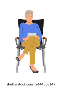Senior woman sitting, working on digital tablet.