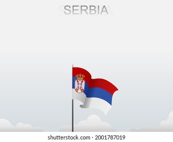 Serbian flag flying on a pole standing tall under a white sky