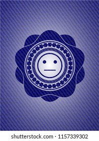 serious face icon inside badge with denim texture