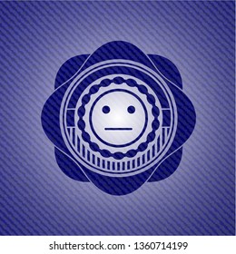 serious face icon inside badge with denim background