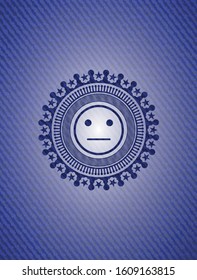 serious face icon inside badge with denim texture