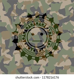serious face icon inside camouflaged emblem