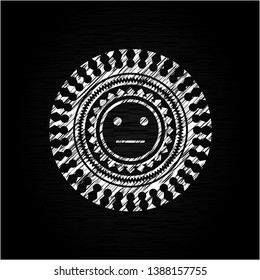 serious face icon inside chalkboard emblem written on a blackboard