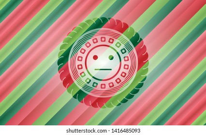 serious face icon inside christmas colors badge.