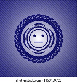 serious face icon inside emblem with denim texture