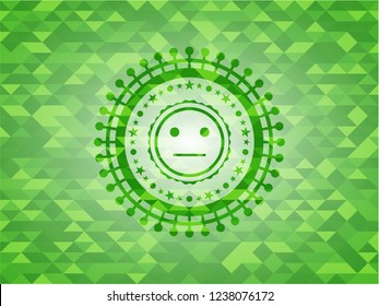 serious face icon inside green emblem with triangle mosaic background