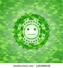 serious face icon inside green mosaic emblem