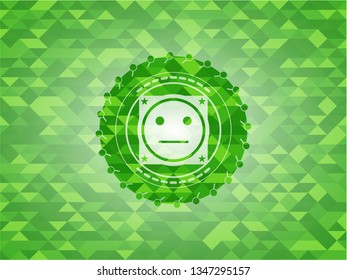 serious face icon inside green mosaic emblem