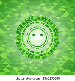 serious face icon inside green emblem with triangle mosaic background