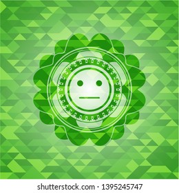 serious face icon inside green mosaic emblem