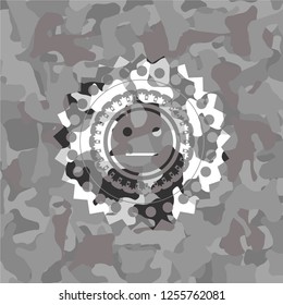 serious face icon inside grey camouflage emblem