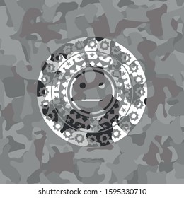 serious face icon inside grey camouflage emblem
