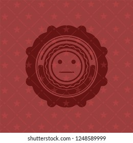 serious face icon inside realistic red emblem