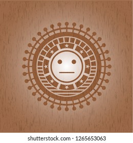 serious face icon inside realistic wood emblem