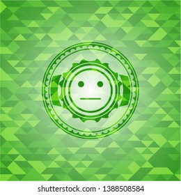 serious face icon inside realistic green mosaic emblem