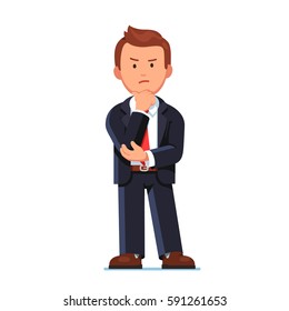 Serious frowned business man in black suit standing with angry, annoyed face. Office worker or boss knitting brows and holding hand on chin doubting about something. Flat style vector illustration.