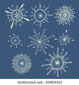 Set of 8 hand drawn strange white snowflakes isolated on a blue background. Traditional xmas and new year decoration elements for creative design.