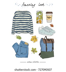 A set of autumn outfit with accessories: pullover in black and white stripes, stylish jeans, sneakers, city backpack, coffee in a paper glass, a phone case with an autumn print, falling leaves.