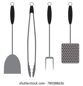 A set of barbecue tools including a spatula, tongs, fork and brush are ready for use
