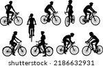 A set of bicyclists riding bikes and wearing a safety helmet in silhouette
