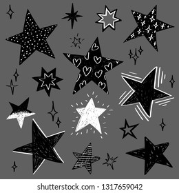 Set of black and white hand drawn vector stars in doodle style isolated on gray background. Could be used as pattern element, cards, childish design