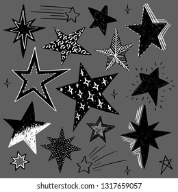 Set of black and white hand drawn vector stars in doodle style isolated on gray background. Could be used as pattern element, cards, childish design