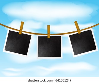 Set of blank photo frames hanging on the rope with wood pins on sky background