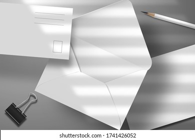 Set of blank white postcard, envelope,  pencil and binder. Mockup template  for branding.  Light from the window through the jalousie