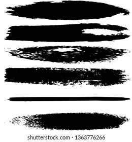 A set of brush strokes of black paint on a white background. Collection of abstract spots