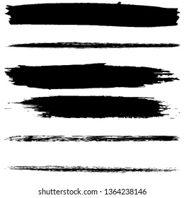 A set of brush strokes of black paint on a white background. Collection of abstract spots