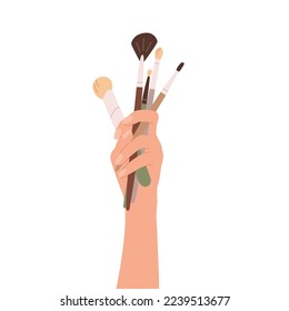 Conjunto de pinceles para maquillaje. Ilustración vectorial plana de la mano del artista de maquillaje sujetando la colección de accesorios cosméticos para la pintura facial. Cepillo para pradera de ojos, cejas, rubor